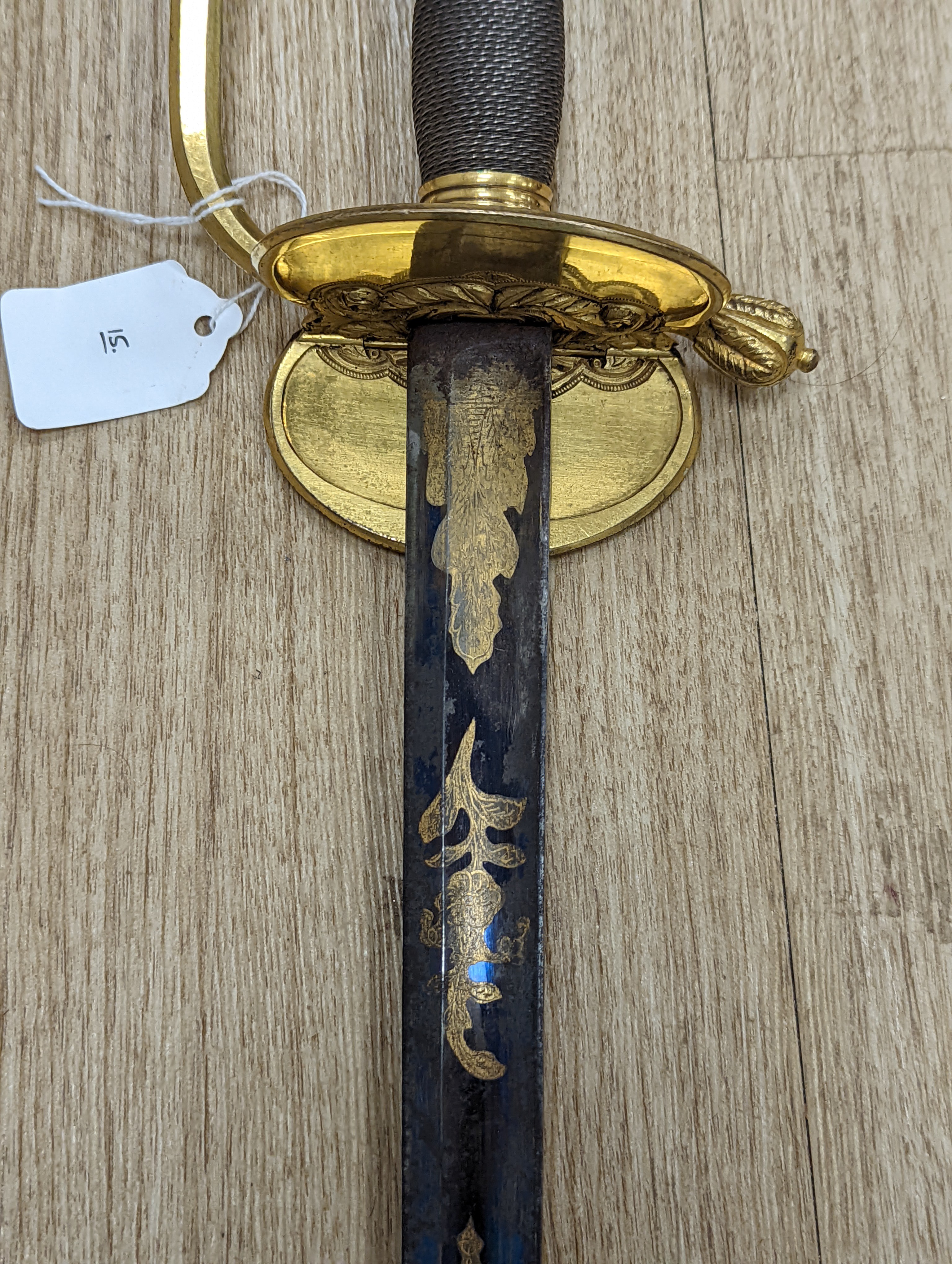 A fine Georgian officer’s sword, blade etched blued and gilt with crowned GR, royal arms and trophy of arms, gilt handle with folding side guard, silver wire bound grip, blade 81cms.